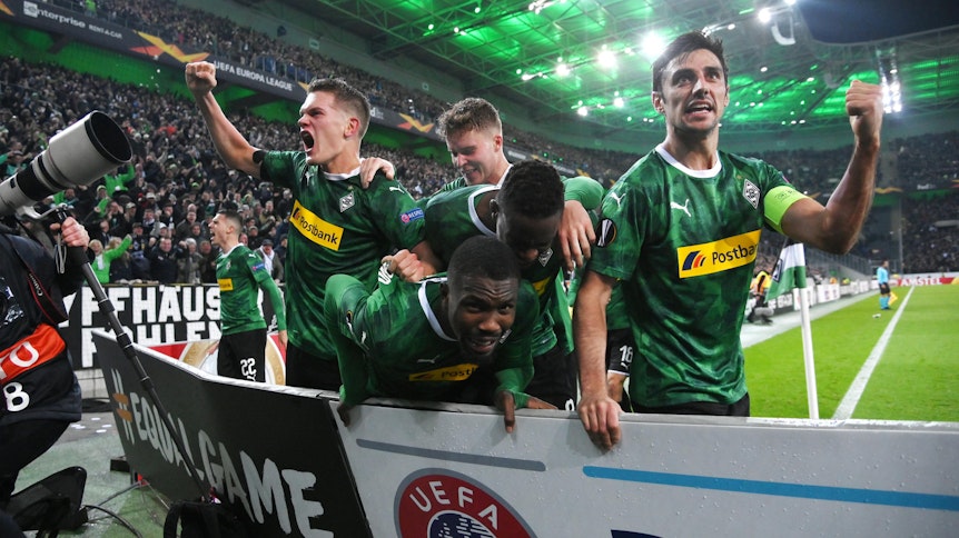 Marcus Thuram verschwindet nach seinem Tor gegen die AS Rom in der Jubeltraube von Borussia Mönchengladbach.