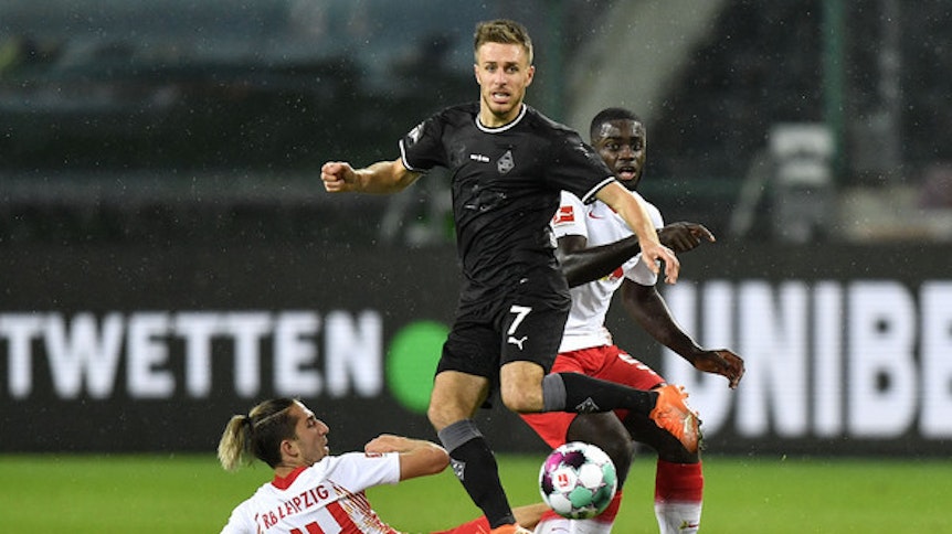 Der Leipziger Kevin Kampl liegt am Boden, Gladbachs Offensivspieler Patrick Herrmann (M.) setzt sich im Duell der beiden Vereine Ende Oktober durch, Gegenspieler Dayot Upamecano schaut zu.
