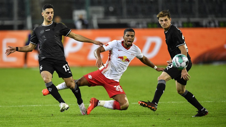 Die Gladbacher Lars Stindl (l.) und Jonas Hofmann (r.) stoppen Leipzigs Benjamin Henrichs (m.)