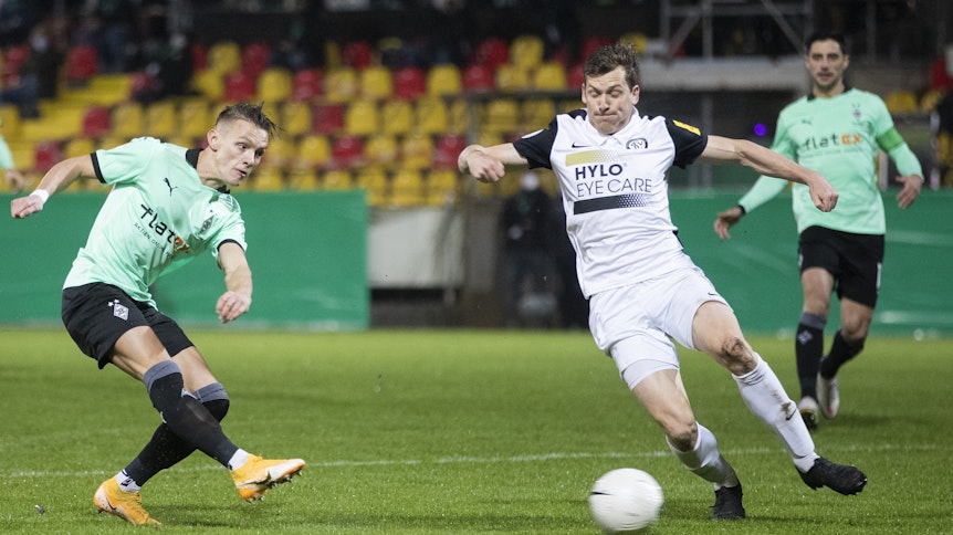 Gladbachs Hannes Wolf (l) macht das Tor zum 0:1 gegen Elversbergs Lukas Kohler (M).