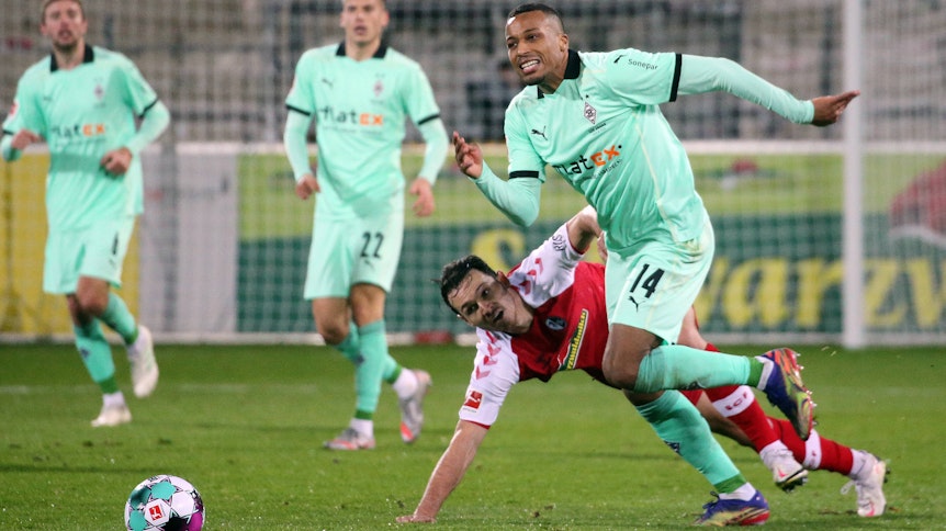 Alassane Plea (r.). hier im Zweikampf mit Freiburgs Nicolas Höfler, beim Bundesliga Spiel der Fohlen beim SC Freiburg am 5. Dezember 2020.