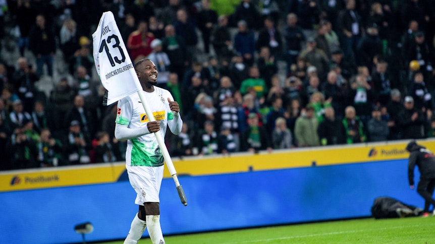 Gladbachs Stürmer Marcus Thuram bejubelt den Sieg gegen Eintracht Frankfurt am 27. Oktober 2019 mit der Eckfahne und dem Trikot von Mitspieler Lars Stindl.