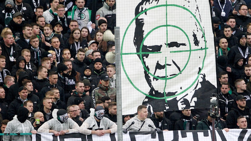 Ultras von Borussia Mönchengladbach zeigen einen Doppelhalter mit dem Gesicht von Hoffenheim-Mäzen Dietmar Hopp hinter einem Fadenkreuz.
