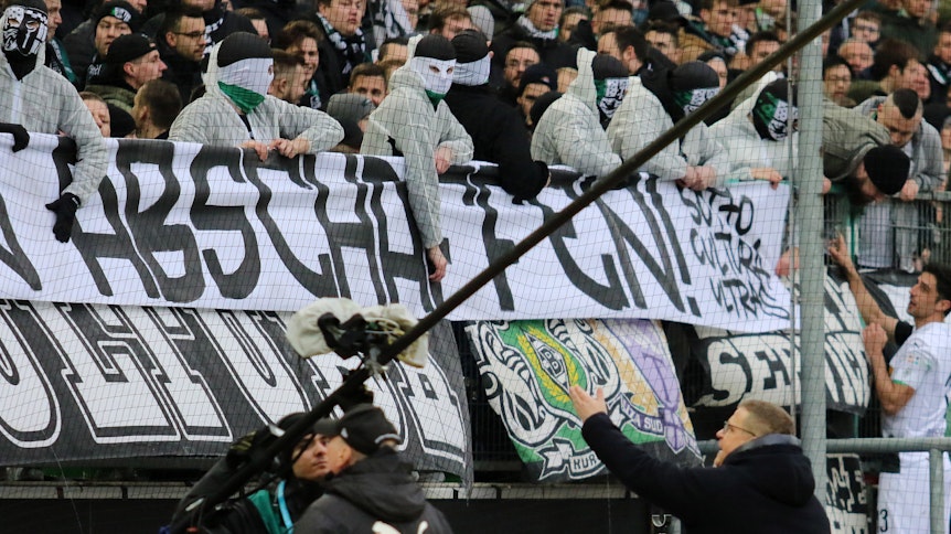Gladbachs Manager Max Eberl gemeinsam mit Kapitän Lars Stindl im Kampf gegen Chaoten im eigenen Fan-Block. Diese haben nicht nur Hass-Banner, sondern auch Maler-Anzüge und Sturm-Hauben ins Stadion geschmuggelt.