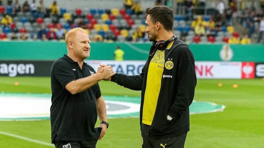 Heiko Vogel begrüßt seinen ehemaligen Schützling aus der Jugend des FC Bayern, Mats Hummels. Das Foto entstand vor dem Pokalspiel zwischen dem KFC Uerdingen und Borussia Dortmund im Jahr 2019.