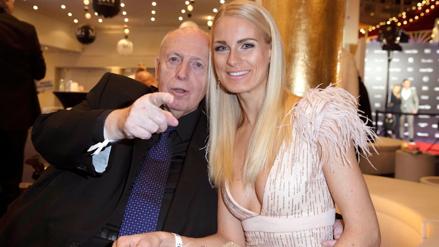 Reiner Calmund zeigt mit dem Finger Richtung Kamera, während er in in der Europa-Park Arena in Rust neben Anne-Kathrin Kosch sitzt.