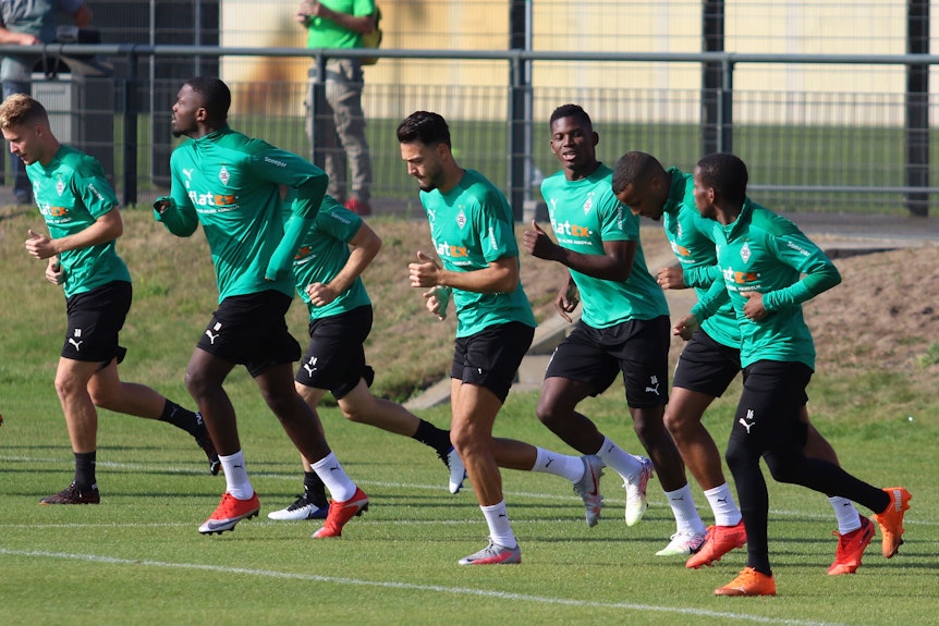 Borussia Mönchengladbach wärmt sich vor dem Teamtraining auf.