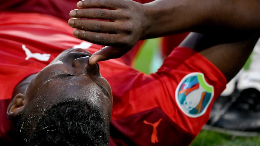 Gladbachs Breel Embolo zog sich im EM-Viertelfinale der Schweiz gegen Spanien am 2. Juli 2021 in St. Petersburg eine Oberschenkelverletzung zu und fällt nun bis auf Weiteres aus. Das Foto zeigt den Schweizer mit Schmerz verzerrtem Gesicht leidend auf dem Boden liegend.
