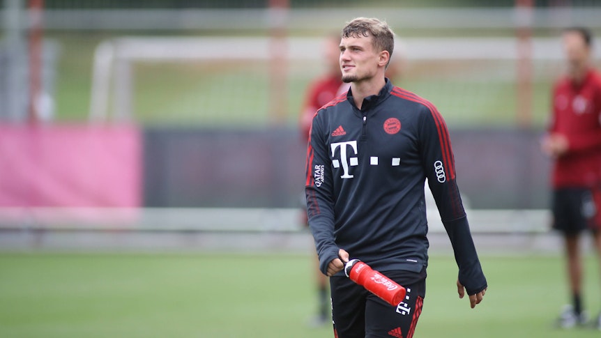 Michael Cuisance beim Training des FC Bayern München, läuft über den Platz und trägt eine rote Trinkflasche mit sich.
