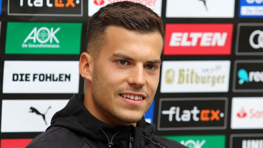 László Bénes spricht im Trainingslager in Harsewinkel am 19. Juli zu den anwesenden Pressevertretern und lächelt.