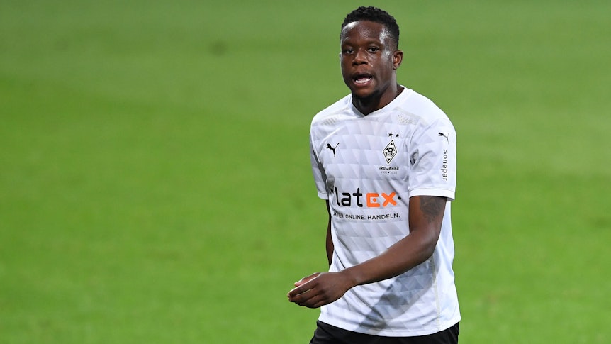 Denis Zakaria läuft im weißen Gladbach-Trikot über den Fußballplatz, er schaut angestrengt.