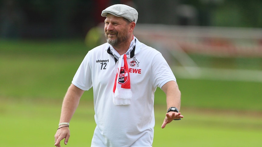 Der neue Trainer des 1. FC Köln heißt Steffen Baumgart. Auf diesem Foto ist der Fußballlehrer mit einem Fanschal und Mütze zu sehen.