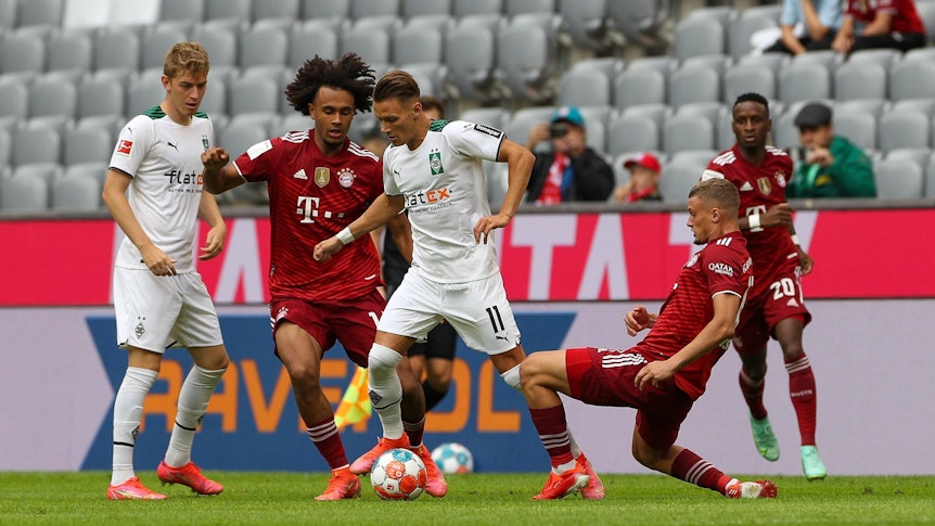 Bayerns Joshua Zirkzee Im Zweikampf mit den Gladbachern Andreas Poulsen (l) und Hannes Wolf (r.) während des Testspiels am 28. Juli 2021.