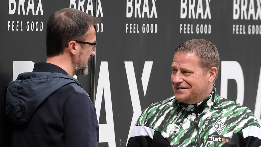 Gladbachs Manager Max Eberl (r.) unterhält sich am 17. April 2021 im Borussia-Park am Spielfeldrand mit Fredi Bobic (l.). Beide lächeln dabei.