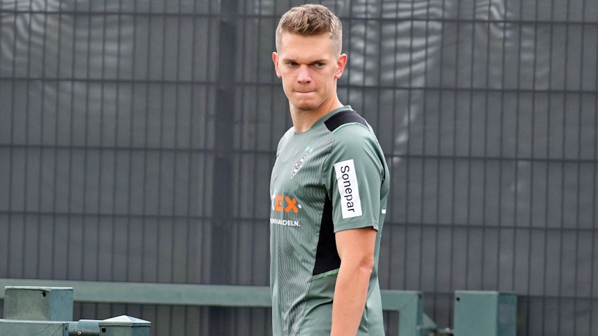 Matthias Giner läuft mit ernstem Gesicht über den Trainingsplatz, er blickt nach unten.