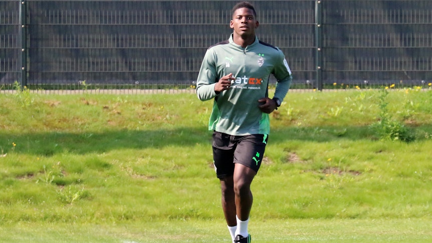 Stürmer Breel Embolo joggt über das Trainingsgelände im Borussia-Park, dabei blickt der Schweizer Nationalspieler in die Kamera des Fotografen Dirk Päffgen.