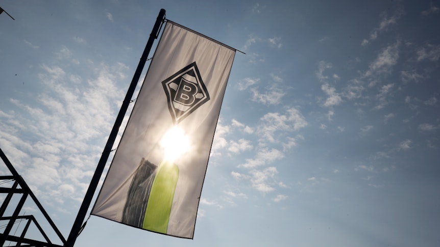 Die Vereinsfahne von Borussia Mönchengladbach weht vor der Sonne.