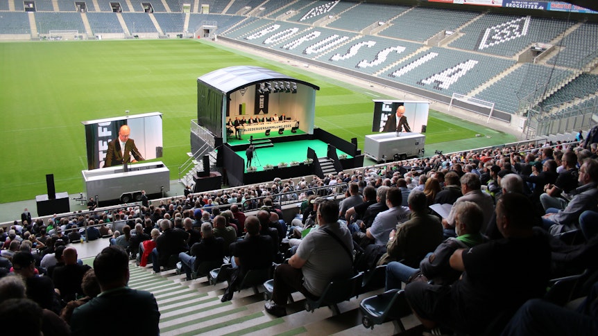 Mitglieder von Borussia Mönchengladbach sitzen auf der Südtribüne des Borussia-Parks und hören zu, was das Präsidium des VfL zu berichten hat.