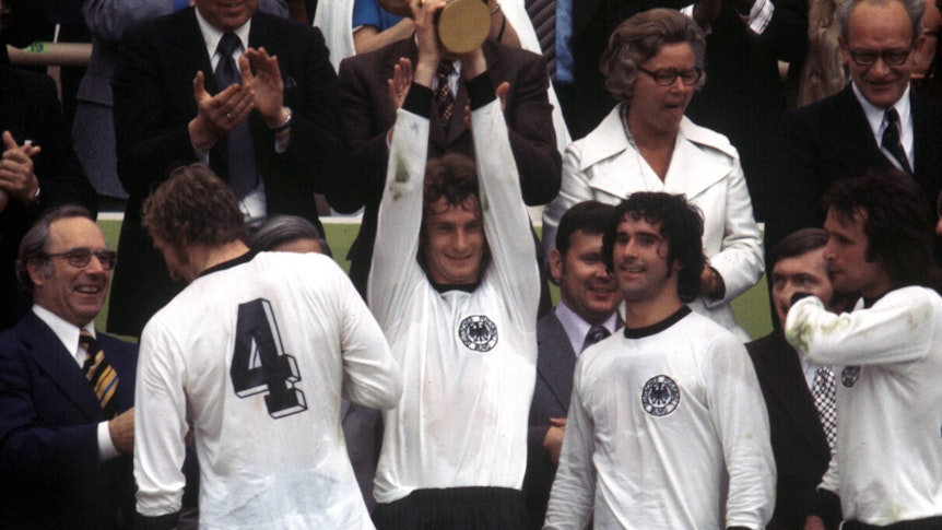 WM 1974, Siegerehrung Weltmeister BR Deutschland - Rainer Bonhof präsentiert den Pokal, daneben Hans Georg -Katsche- Schwarzenbeck, Gerd Müller und Wolfgang Overath World Cup 1974 Award Ceremony World Champion BR Germany Rainer Bonhof presents the Cup next to it Hans Georg Katsche Schwarzenbeck Gerd Mueller and Wolfgang Overath