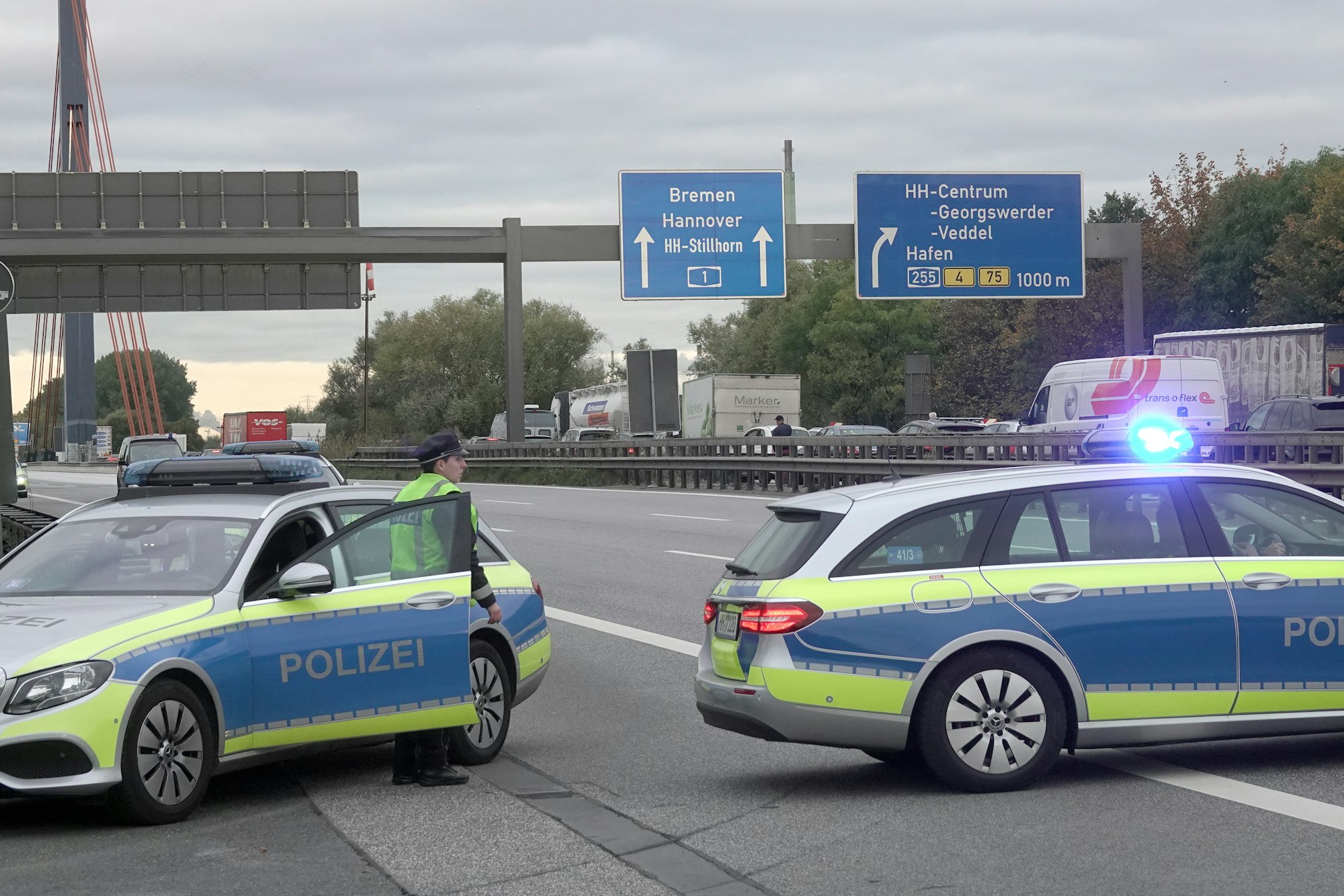Einsatzfahrzeuge der Polizei stehen auf der gesperrten Autobahn 1.