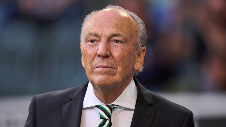 Gladbachs Präsident Rolf Königs steht beim Bundesliga-Spiel zwischen Borussia und Bayern München am 13. August 2021 im Borussia-Park lächelnd am Spielfeldrand.