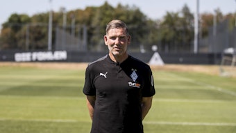 Gladbach-Legende und Torwarttrainer Uwe Kamps blickt in die Kamera, seine Arme hat er auf dem Rücken verschränkt.