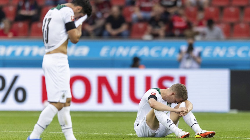 Gladbachs Matthias Ginter musste im Duell mit Bayer Leverkusen am 21. August 2021 in der BayArena verletzt ausgewechselt werden. Das Foto zeigt ihn mit hängendem Kopf auf dem Rasen sitzend.
