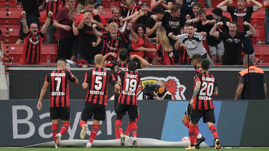 Leverkusens Spieler um Patrik Schick feiern beim Bundesliga-Sieg (21. August 2021) gegen Gladbach (4:0) mit den Fans einen Treffer. Die Fans sind aus dem Häuschen.