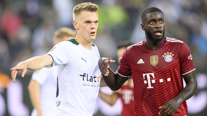 Gladbachs Nationalspieler Matthias Ginter (l.) im Duell mit Bayern-München-Verteidiger Dayot Upamecano (r.) beim Bundesliga-Spiel am 13. August 2021. Beide Spieler blicken auf den Ball.