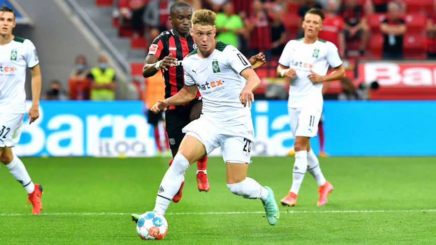 Gladbachs neuer Linksverteidiger Luca Netz (Mitte) ist beim 0:4 in Leverkusen (21. August 2021) erstmals für die Borussia in der Bundesliga zum Einsatz gekommen. In dieser Szene kontrolliert er mit dem rechten Fuß den Ball.