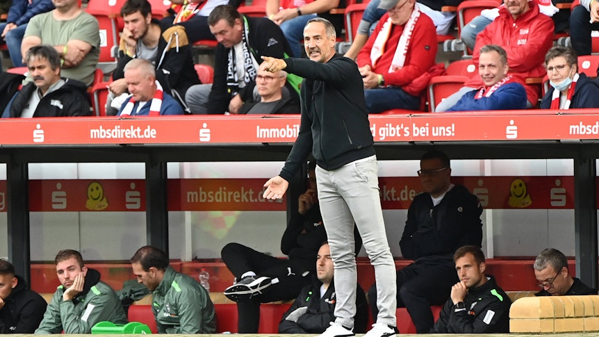 Adi Hütter, im Spiel der Gladbacher bei Union Berlin am 29. August 2021, hat den Arm ausgestreckt und deutet mit seinem Zeigefinger auf das Fußballfeld.