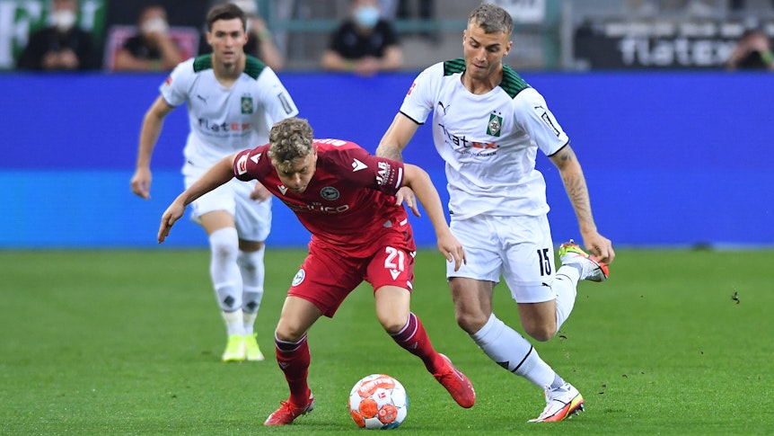 Am Sonntag (12. September 2021) trifft Gladbach im Bundesliga-Duell auf Arminia Bielefeld. Das Foto zeigt Bielefelds Robin Hack (l.) im Duell mit Borussias Jordan Beyer.