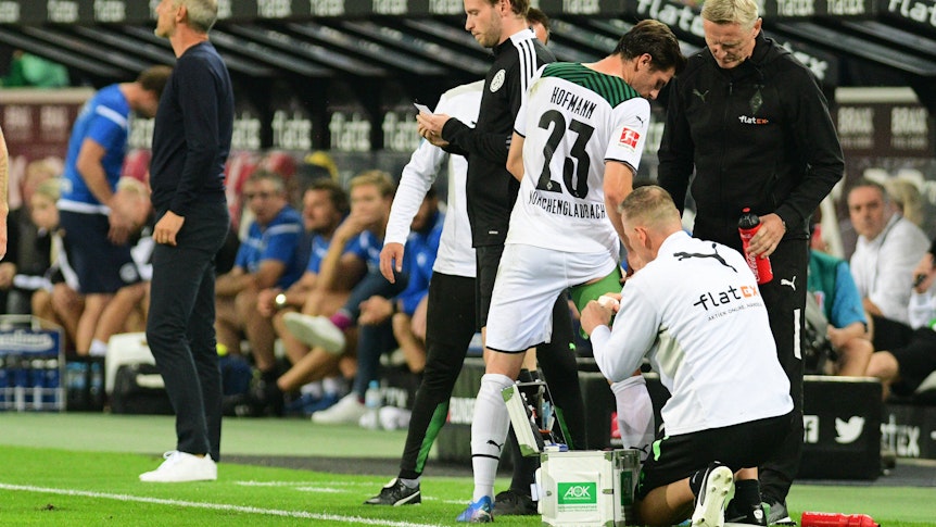 Gladbachs Jonas Hofmann Gladbach bekommt während dem Bundesliga-Spiel gegen Arminia Bielefeld am 12. September 2021 im Borussia-Park von Physiotherapeut Dirk Mueller (re.) den Oberschenkel bandagiert.