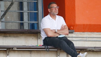 Uwe Kamps, Torwarttrainer von Borussia Mönchengladbach, beobachtet am 21. August 2021 im Rheydter Grenzlandstadion das Regionalliga-Spiel zwischen Borussias U23 und Preußen Münster. Kamps sitzt auf der Tribüne und schaut nach vorne.