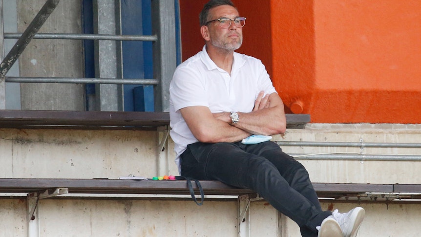 Uwe Kamps, Torwarttrainer von Borussia Mönchengladbach, beobachtet am 21. August 2021 im Rheydter Grenzlandstadion das Regionalliga-Spiel zwischen Borussias U23 und Preußen Münster. Kamps sitzt auf der Tribüne und schaut nach vorne.