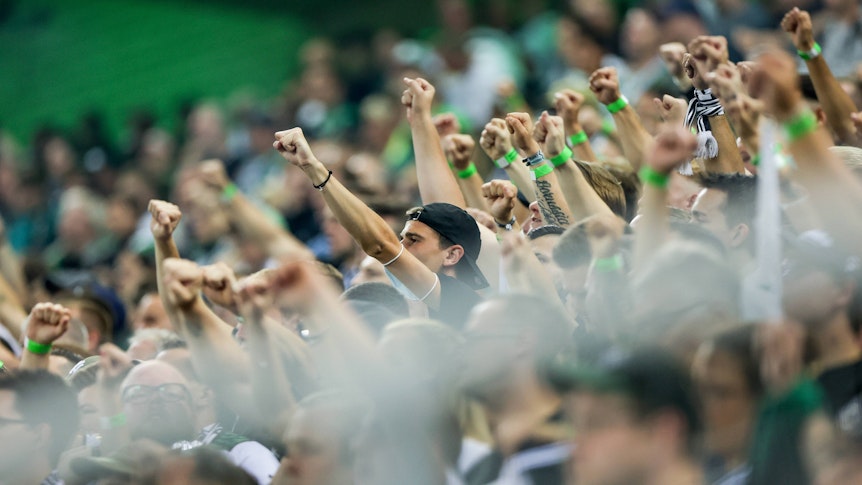 Fans von Borussia Mönchengladbach beim Bundesliga-Duell am 12. September 2021 gegen Arminia Bielefeld im Borussia-Park. Zahlreiche Fans strecken ihre Arme nach oben.