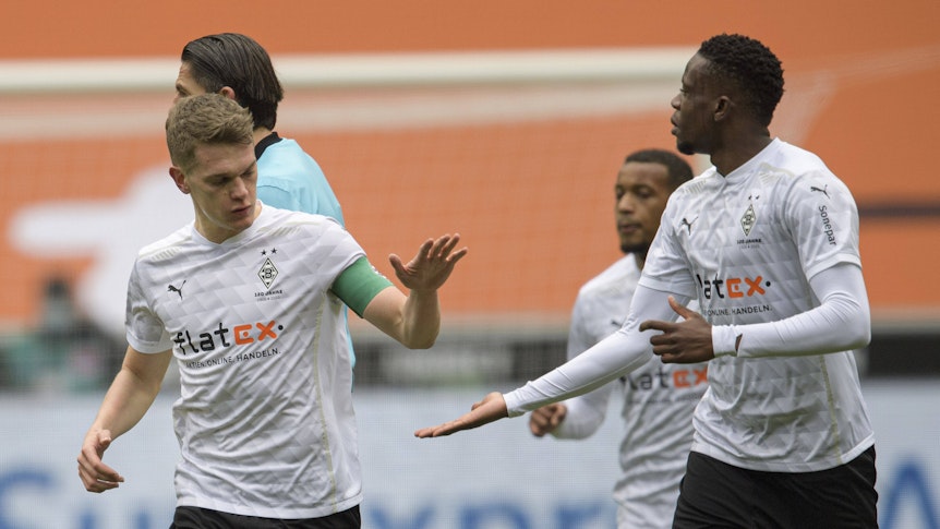 Die beiden Nationalspieler Matthias Ginter (l.) und Denis Zakaria (r.) klatschen sich am 17. April 2021 gegenseitig im Borussia-Park ab. Ginter und Zakaria haben bei Borussia Mönchengladbach noch einen Vertrag bis 2022. Ginter trägt in diesem Spiel gegen Eintracht Frankfurt die Kapitänsbinde.