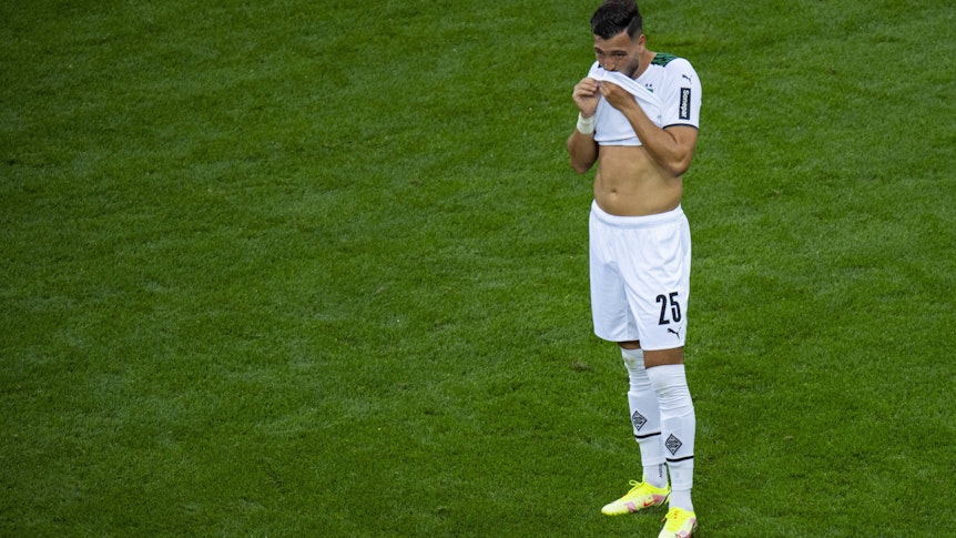 Ramy Bensebaini von Borussia Mönchengladbach wischt sich beim Bundesliga-Spiel gegen bei Bayer Leverkusen am 21. August 2021 den Mund am Trikot ab.