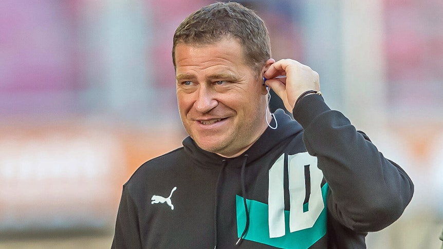 Gladbach-Manager Max Eberl. Auf diesem Foto ist der 47-Jährige am 18. September 2021 im Augsburger Stadion zu sehen. Eberl ist beim TV-Sender Sky zu Gast und bereitet sich auf ein Interview vor. In sein linkes Ohr steckt er einen Kopfhörer.