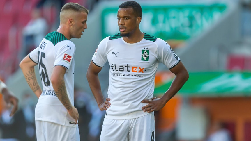 Alassane Plea (l.) und Jordan Beyer (r.) von Borussia Mönchengladbach stehen am 18. September 2021 mit den Händen in den Hüften auf den Fußballplatz und schauen enttäuscht.