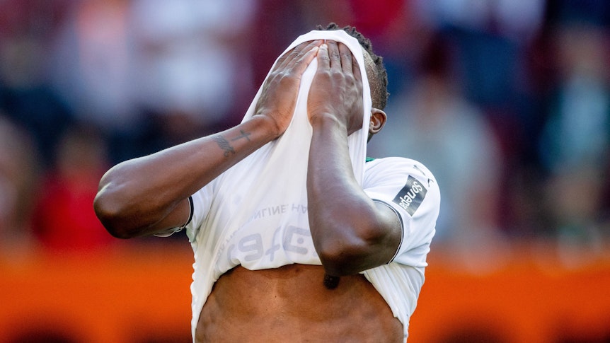 Denis Zakaria von Borussia Mönchengladbach hält sich nach der Niederlage beim FC Augsburg am 18. September 2021 enttäuscht die Hände vor sein Gesicht.