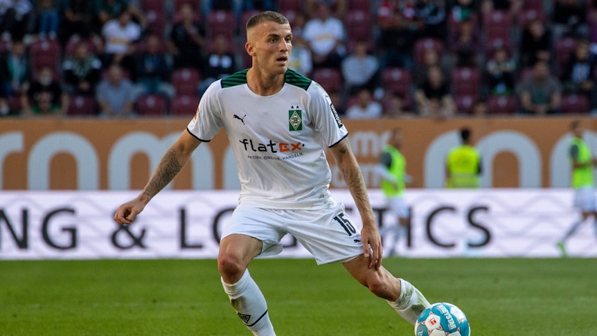 Louis Jordan Beyer von Borussia Mönchengladbach, hier zu sehen am 18. September 2021 in Augsburg, ist für die U21-Nationalelf des DFB nominiert worden. Beyer blickt auf das Spielfeld, während der Ball vor ihm ist.