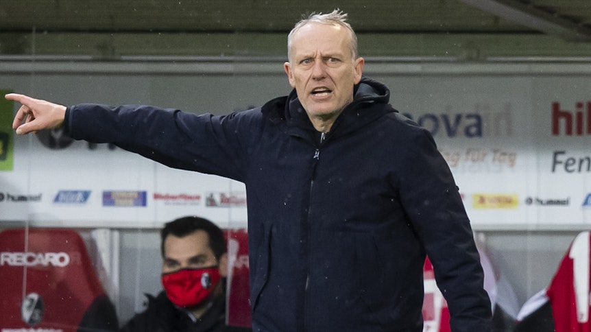 Freiburgs Trainer Christian Streich, hier am 12.12.2020 beim Duell gegen Arminia Bielefeld, zeigt mit der rechten Hand Richtung Spielfeld.