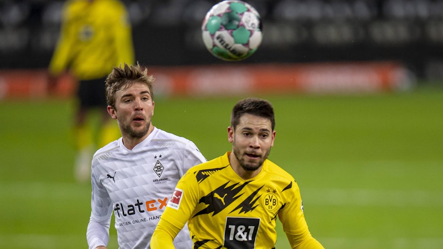 Gladbachs Mittelfeldspieler Christoph Kramer (l.) und Dortmunds Raphael Guerreiro (r.) blicken im Bundesliga-Duell am 22. Januar 2021 auf den Ball.