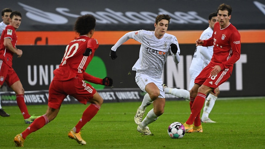 Gladbachs Nationalspieler Florian Neuhaus (Mitte) setzt sich beim 3:2-Sieg der Borussia gegen Bayern München am 8. Januar 2021 gegen Goretzka (r.) und Sane (l.) durch.