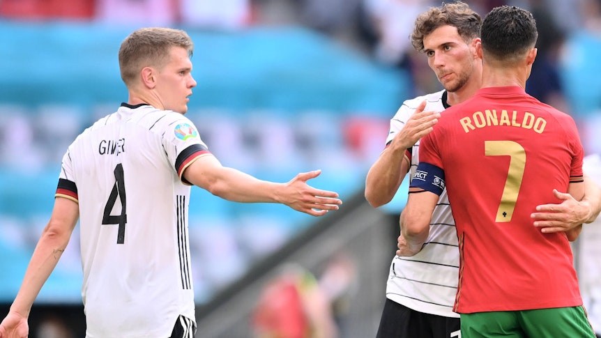 Matthias Ginter (l.), Verteidiger von Borussia Mönchengladbach, ist von Bundestrainer Hansi Flick zurück in den Kreis der DFB-Auswahl berufen worden. Auf diesem Foto ist Ginter am 19. Juni 2021 beim EM-Duell gegen Portugal im München zu sehen. Rechts im Bild umarmen sich Leon Goretzka und Cristiano Ronaldo.