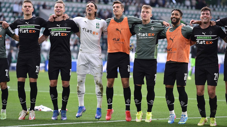 Die Mannschaft von Borussia Mönchengladbach hüpft Arm in Arm nach dem ersten Auswärtsdreier Saison beim VfL Wolfsburg am 2. Oktober 2021.