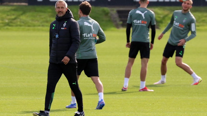 Adi Hütter, Trainer von Borussia Mönchengladbach, hier am 30. September 2021, läuft über den Trainingsplatz. Im Hintergrund trainieren drei Gladbach-Spieler-