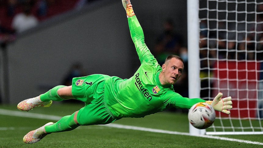 Torhüter Marc André ter Stegen ist bei Borussia Mönchengladbach zum Profi gereift und steht seit 2014 beim spanischen Klub FC Barcelona unter Vertrag. Auf diesem Foto ist ter Stegen bei einer Parade am 3. Oktober 2021 im Stadion von Atletico Madrid zu sehen. Er springt in die Ecke des Tores.