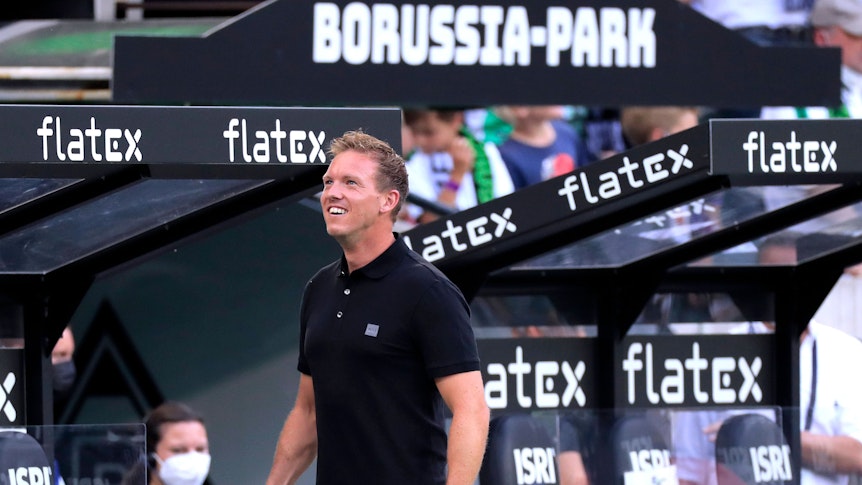 Julian Nagelsmann, Trainer des FC Bayern München, auf diesem Foto beim Bundesliga-Duell gegen Borussia Mönchengladbach am 13. August 2021 im Borussia-Park zu sehen. Nagelsmann schaut hoch und lächelt.